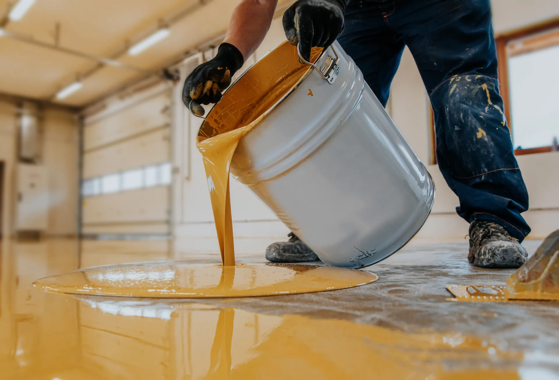 Pouring the polyurea base coat onto the prepped slab